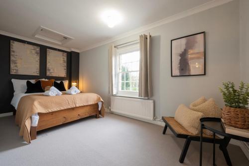 a bedroom with a bed and a window and a chair at Charming 3BR Cottage Sleeps 8 - 15 Mins to Centre in Wickhambreaux