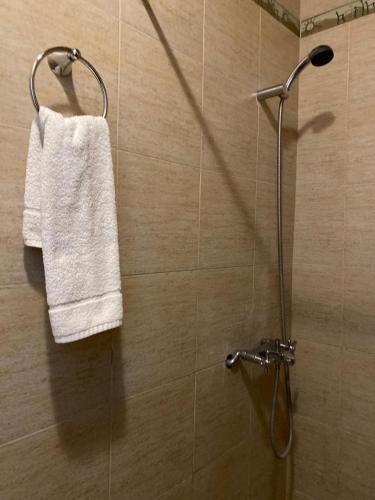 a shower with a white towel hanging on a wall at Cabana Mirador Sumajpacha in Tilcara