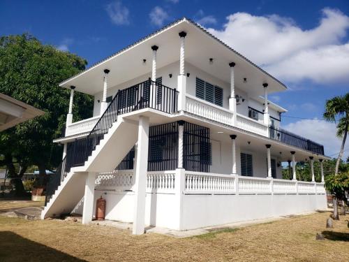 ein großes weißes Haus mit einer Treppe drauf in der Unterkunft 4min walk to corcega beach,spacious 2bedroom 2bath in Rincon