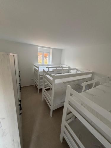 a room with four white bunk beds in it at Hostel 164 in Beograd