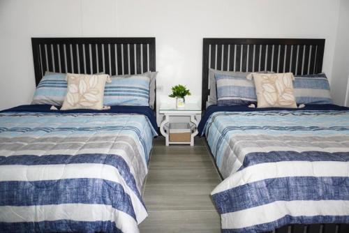 two beds sitting next to each other in a bedroom at Villa Trajano Resort in San Antonio