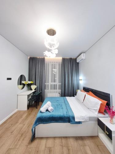 a bedroom with a large bed and a desk at Rich Life in Almaty