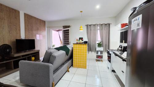 a living room with a couch and a kitchen at Apt perto do shopping in Petrolina