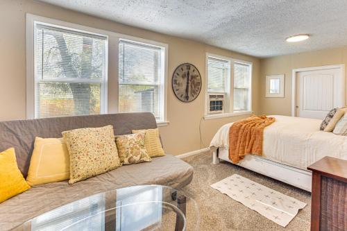 a living room with a couch and a clock on the wall at Pueblo Perfection A Quiet Colorado Adventure! in Pueblo