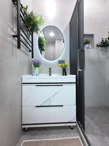 a bathroom with a white sink and a mirror at Rich Life in Almaty