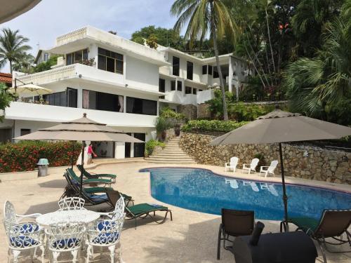 a resort with a swimming pool with chairs and umbrellas at Penthouse VLM Gran Terraza 200 metros vista inmejorable piscina gigante in Acapulco