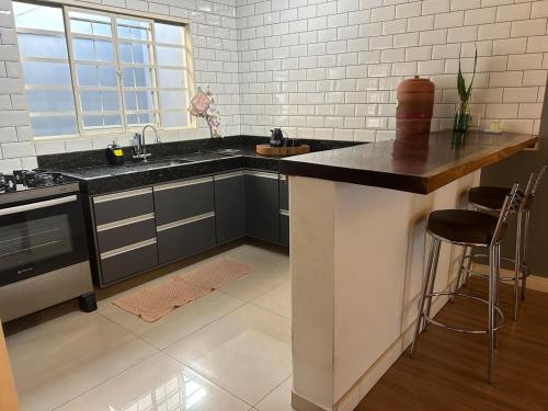 eine Küche mit einer Insel in der Mitte eines Raumes in der Unterkunft Casa Flor - Ribas do Rio Pardo in Ribas do Rio Pardo