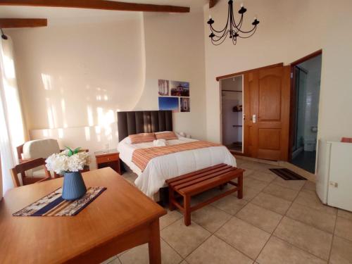a bedroom with a bed and a table and a dining room at Hotel Qhawarina de Casas Kolping Bolivia S.R.L. in Sucre