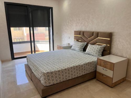 ein Schlafzimmer mit einem großen Bett und einem großen Fenster in der Unterkunft Appartement laimoun in Anfa