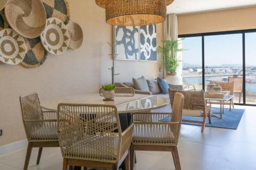 ein Wohnzimmer mit Tisch und Stühlen und einer Couch in der Unterkunft Modern Condo with Pool in Marina Mazatlan in San Rafael