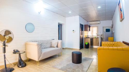 uma sala de estar com um sofá e uma cadeira em Kings Apartment and Suites em Ikeja