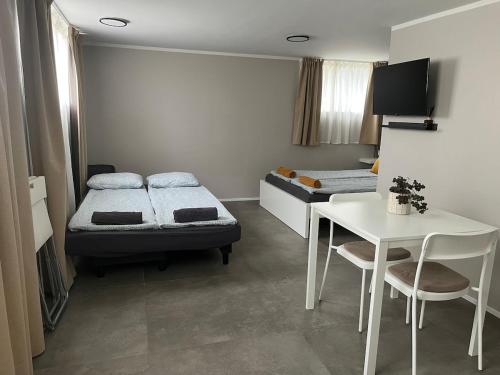 a bedroom with two beds and a table and a table and chairs at Ary & Pablo Airport Stay in Keflavík