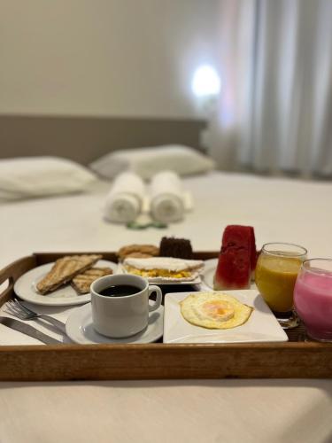 un vassoio con prodotti per la colazione e caffè su un letto di Vila Mar Eco Hotel a Parnaíba