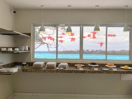 a kitchen with a large window with a view of the ocean at Vila Mar Eco Hotel in Parnaíba
