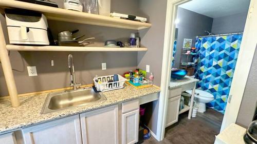 a kitchen with a sink and a bathroom with a toilet at Sunrise Springs in Pahrump