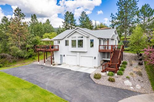 a white house with a porch and a deck at Modern Home with Mountain Views in Missoula