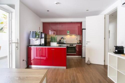 a kitchen with red cabinets and a red refrigerator at Solmare Suites by Atlas in Albufeira