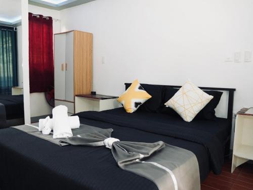 a bedroom with a bed with black sheets and pillows at JLB Resort and Tours,Mango Rooms in Valdez