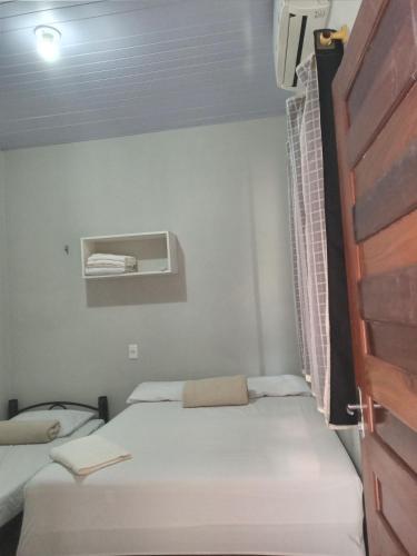 a small room with two beds and a window at Alter do Chão Casa 02 in Alter do Chao