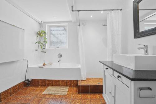 une salle de bain blanche avec une baignoire et un lavabo dans l'établissement Rummeligt Feriehus På Stor Naturgrund, à Langedeby