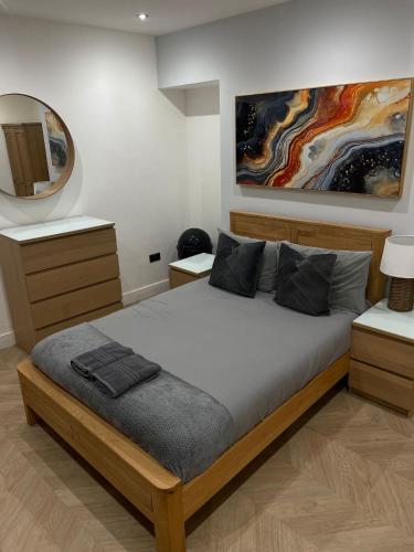 a bedroom with a bed and a painting on the wall at Hendham Rooms - Near Etihad Stadium, CoOp Live Arena, National Cycling Centre & 24 Hour Asda in Manchester