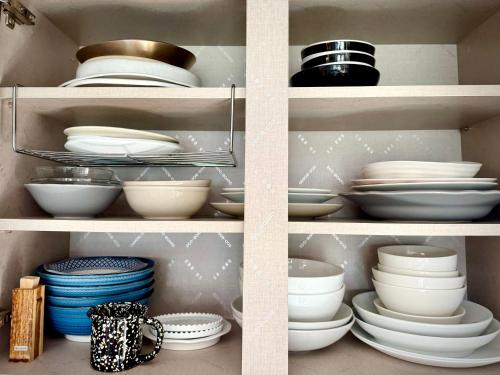 a shelf filled with plates and bowls and dishes at Rooftop House Seongsu in Seoul