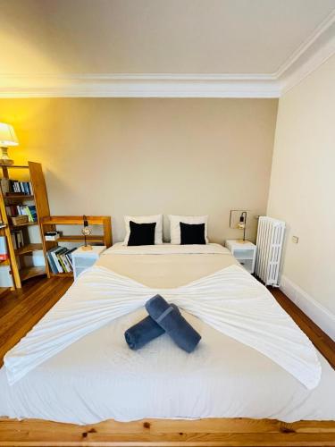 a large bed with a blue bow tie on it at La Maison du Bonheur - 10 people - Close to Paris in Noisy-le-Grand