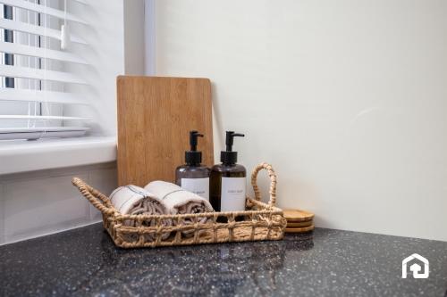 un panier contenant des bouteilles de vin et des serviettes sur un comptoir dans l'établissement Vacant Nests - The Melrose Beach Free Parking, à Woodhorn