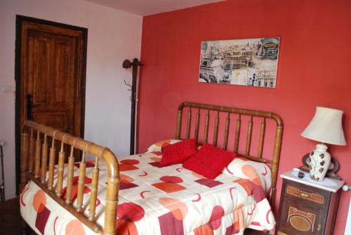 a bedroom with a bed with red walls at Los Polvazares in Castrillo De Los Polvazares