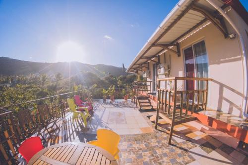 einen Balkon eines Gebäudes mit einem Tisch und Stühlen in der Unterkunft Villa La Romance Kreol in Rodrigues Island