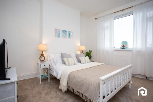 une chambre blanche avec un lit et une fenêtre dans l'établissement Vacant Nests - The Melrose Beach Free Parking, à Woodhorn