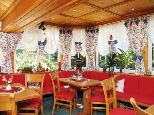 a dining room with red booths and tables and windows at Apartments in Dienten am Hochkönig 225 in Dienten am Hochkönig
