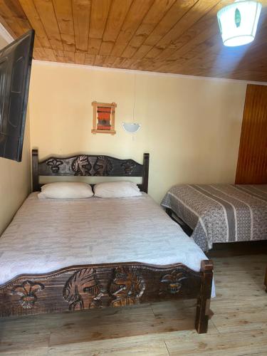 a bedroom with two beds and a tv in it at Hostal Centro in Pichilemu