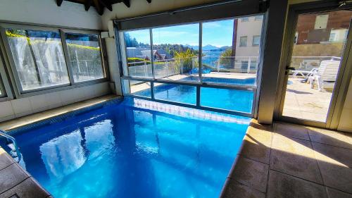 Departamento del Lago II في سان كارلوس دي باريلوتشي: حمام سباحة بمياه زرقاء في منزل