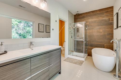 a bathroom with a tub and a sink and a shower at 4 Mi to Dtwn Greenville Group-Ready Home with Yard in Piedmont Park