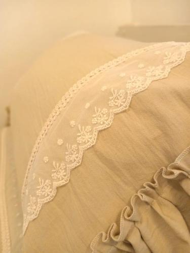 a close up of a white embroidery on a bed at Alojamiento Las Camelias in Concordia