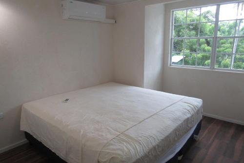 ein Schlafzimmer mit einem Bett in einem Zimmer mit einem Fenster in der Unterkunft 104 Batts Rock Beach Condos near UWI in Saint Michael