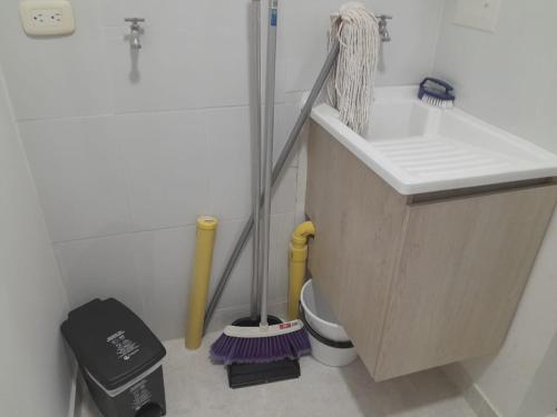 a bathroom with a sink and a toilet with a broom at Beautiful apartment 5 minutes from the Historic Center in Cartagena de Indias