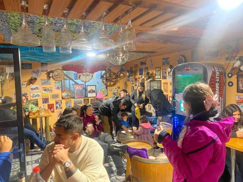 a group of people sitting at a bar in a restaurant at Hostal Centro in Pichilemu