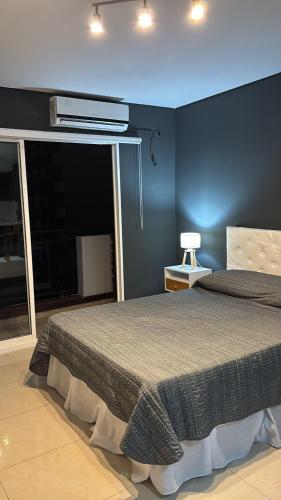 a bedroom with a bed with a blue wall at Ballester apart piscina in Villa Ballester