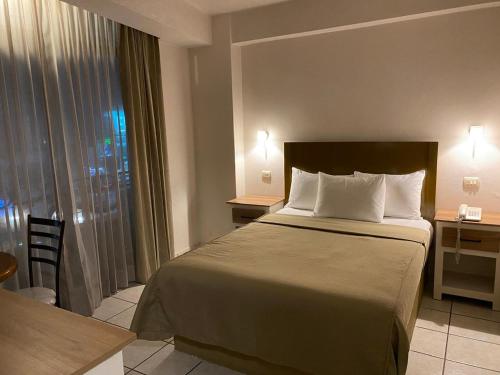 Una habitación de hotel con una cama, un escritorio y una ventana. en Hotel La Vista, en San Martín Texmelucan de Labastida