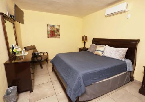 a bedroom with a bed and a dresser and a television at Rocky Point Casa Mango w Pool Walk to Beach in Ciudad Constitución