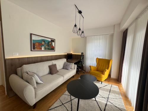 a living room with a couch and a table at UrbanNest Aerodrom in Skopje