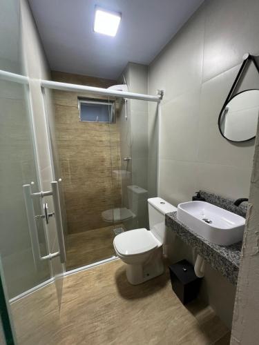 a bathroom with a toilet and a sink and a shower at Esquina 8 Apart in São José
