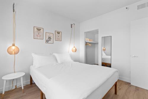 a white bedroom with a white bed and a mirror at Astral Desert Retreats in Mesa
