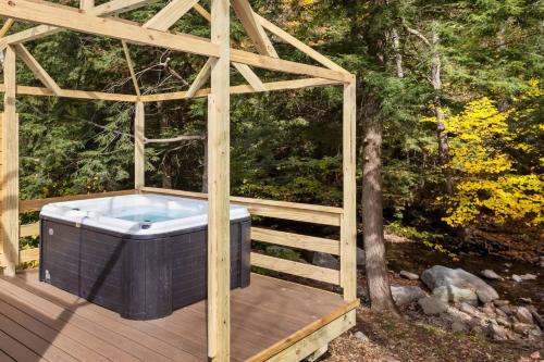a hot tub on a wooden deck at Magic Bus on river w/hot tub at Smuggler's Notch in Morses Mill