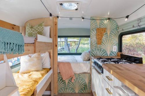 a tiny house with a bedroom and a bed in it at Magic Bus on river w/hot tub at Smuggler's Notch in Morses Mill