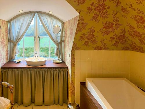 RingeにあるManor House Overlooking Fields And Gardenのバスルーム(洗面台、窓、バスタブ付)