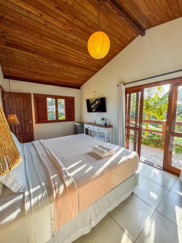 a bedroom with a large bed with a wooden ceiling at Pousada Lagoa do Rosa in Praia do Rosa
