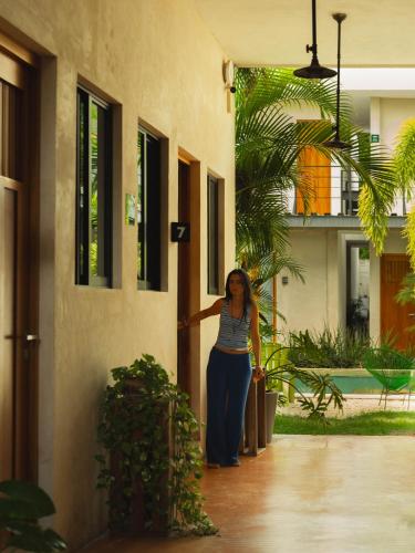 a woman is standing outside of a building at Hostik Hostal in Mérida